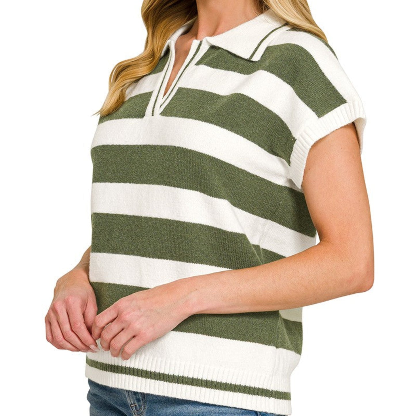 Woman wearing a green and white striped polo shirt with blue jeans on a white background
