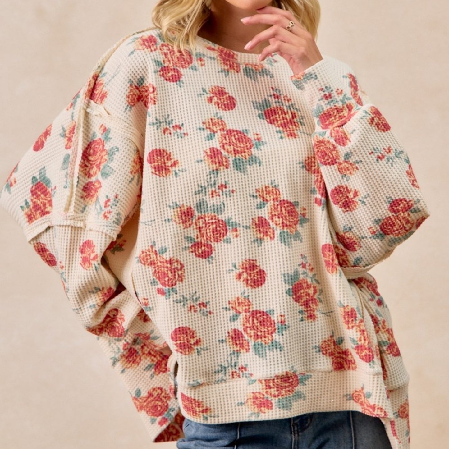 Floral patterned sweater worn by a person on a beige background