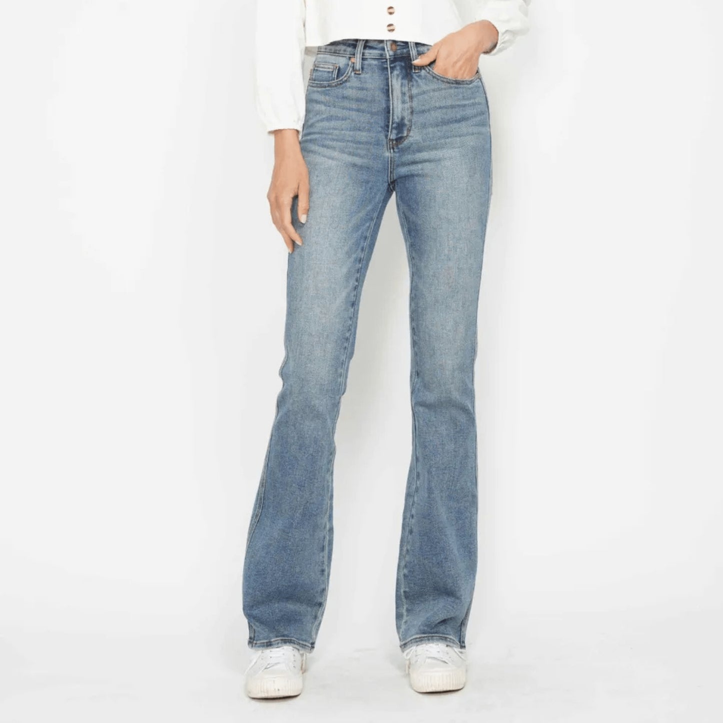 Person wearing light blue jeans on a white background