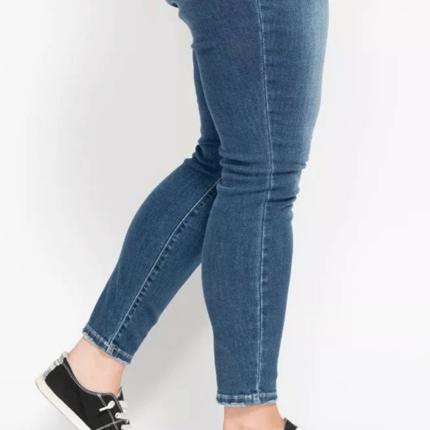 Model wearing the plus size high-rise button-fly skinny jeans.