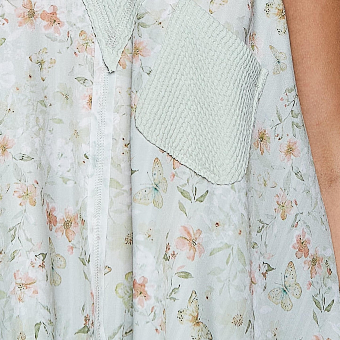 Close-up detail of the front pocket and V-neckline on the sage floral tank.