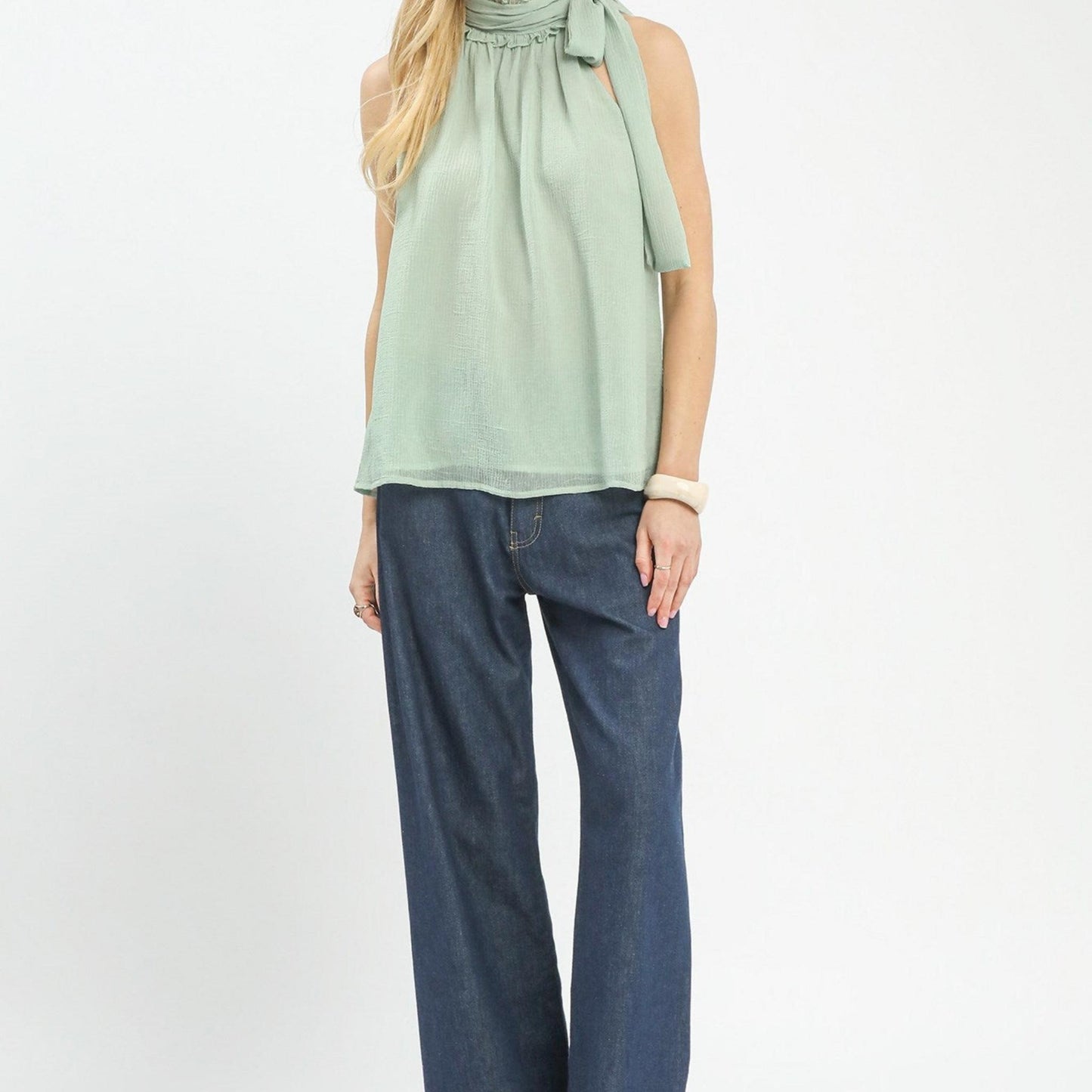 Full-length model shot showing the Umgee mint halter neck top styled with denim.