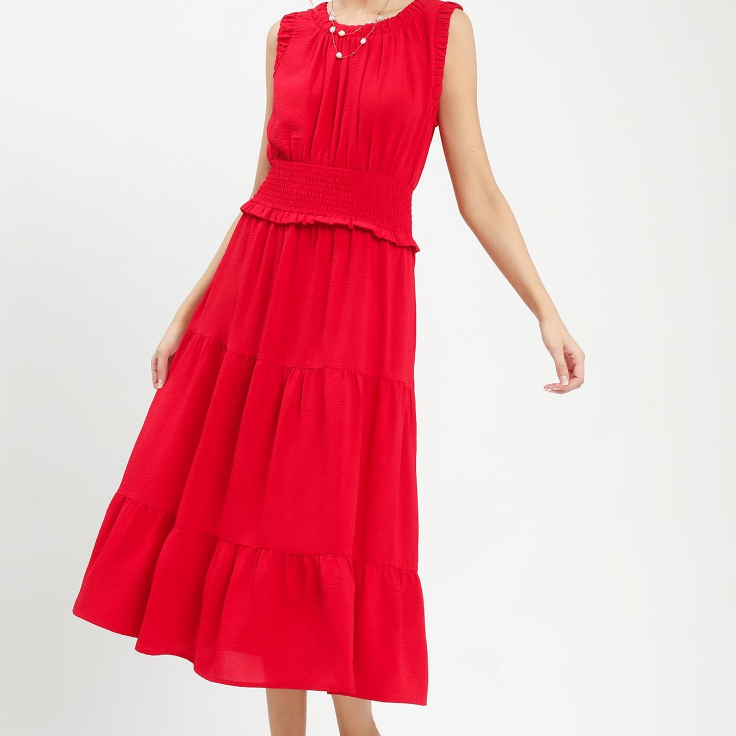 Lifestyle shot of the cherry red smocked dress styled for an outdoor summer event.