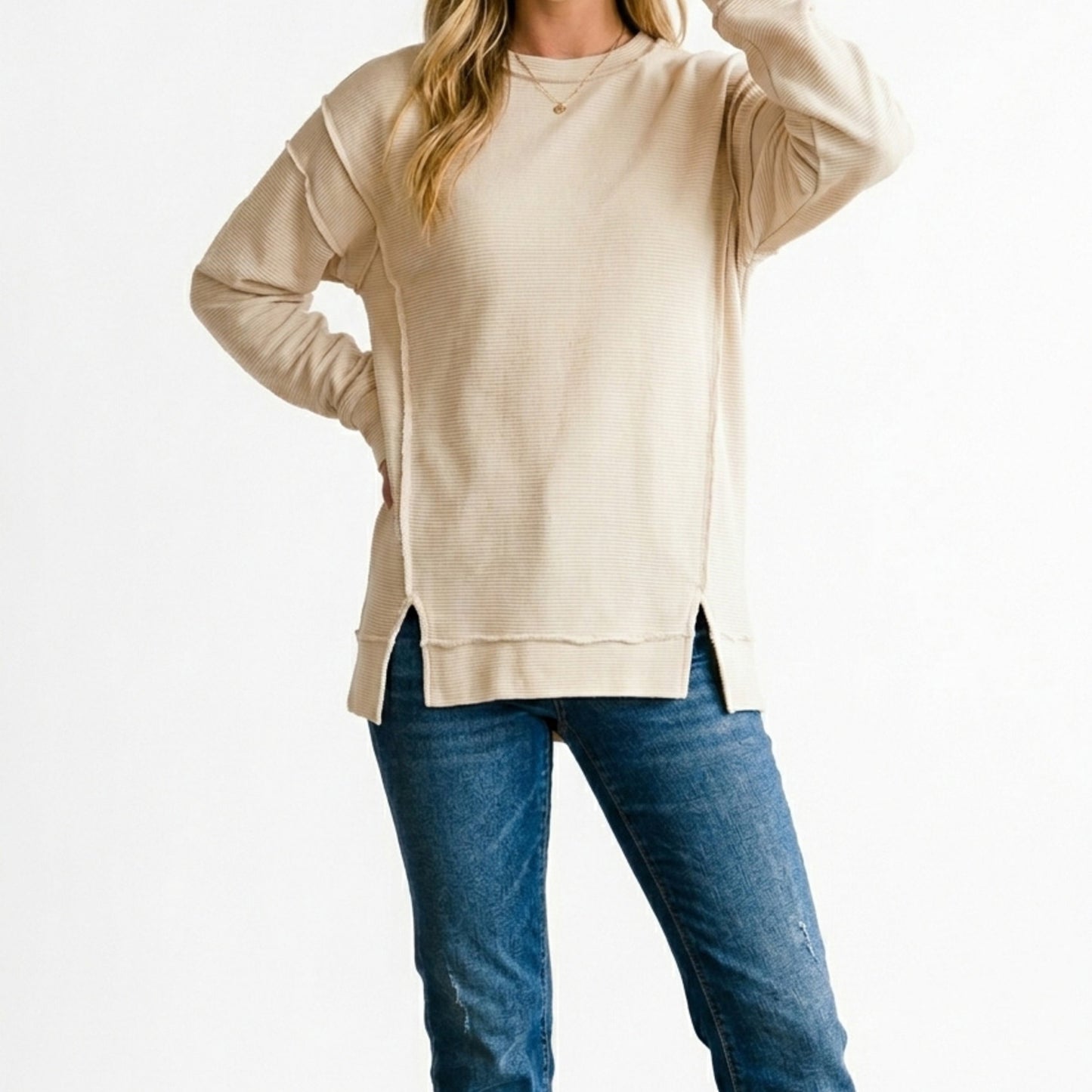 Lifestyle image of the distressed exposed-seam sweatshirt in Sand Beige.