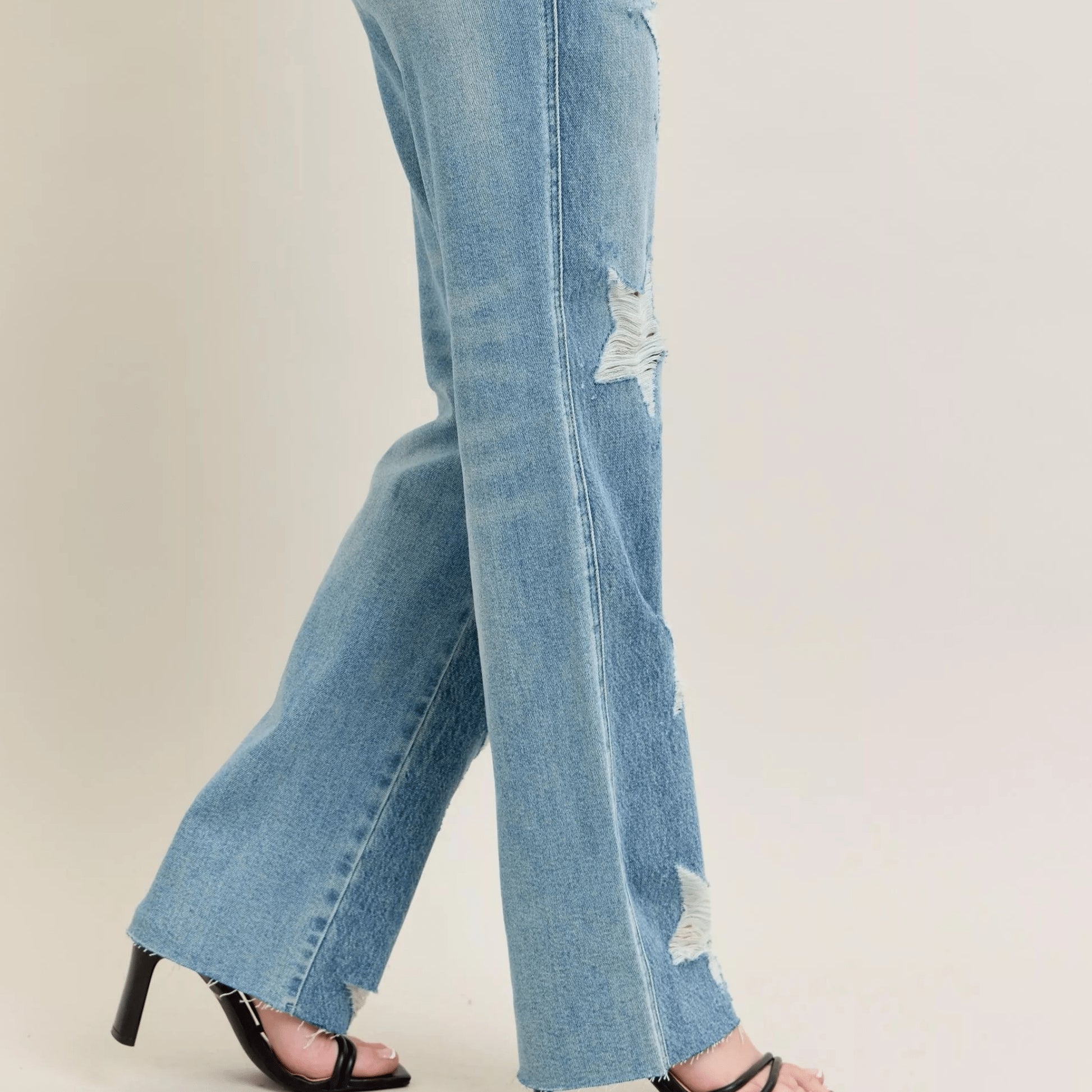 Close-up of the star-shaped distressing on medium wash denim.