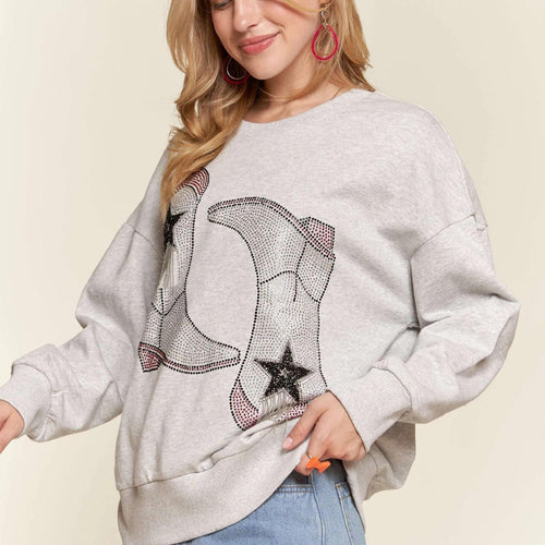 Woman wearing a gray sweatshirt with star and moon design on a beige background