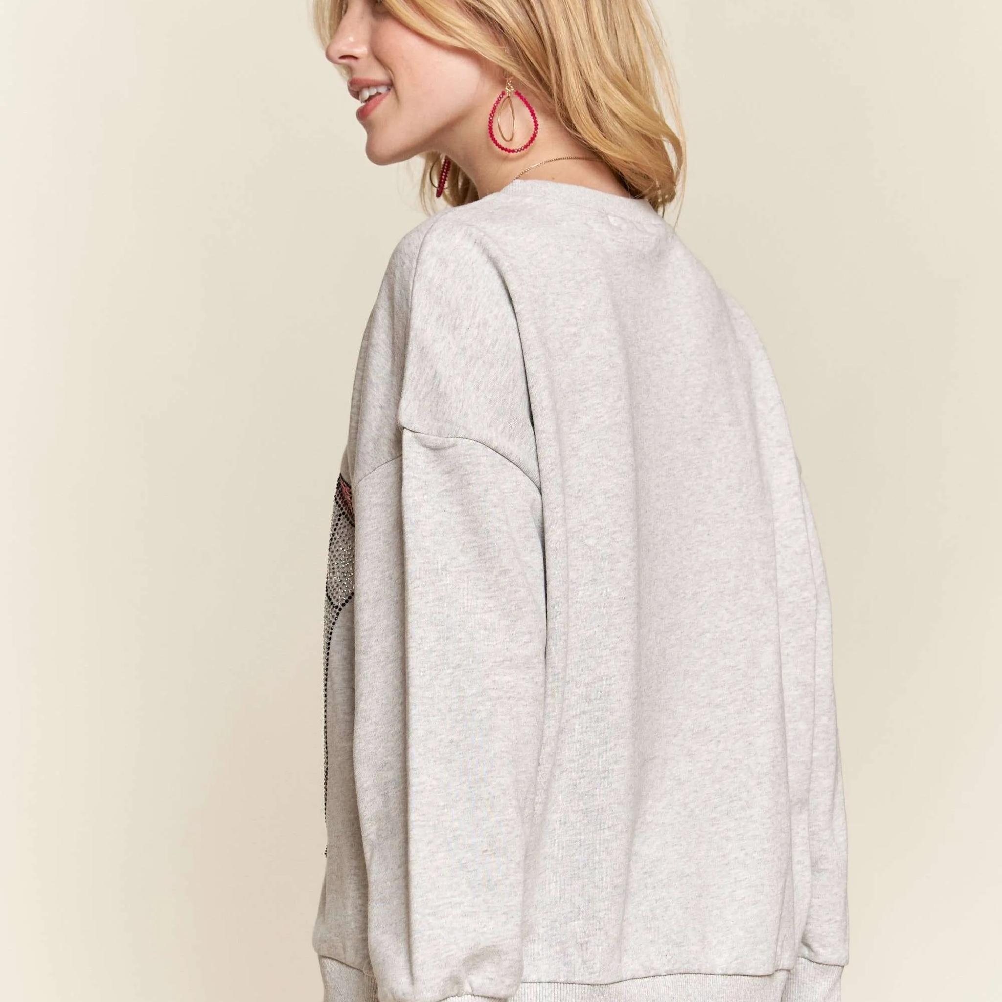 Person wearing a light gray sweatshirt against a beige background