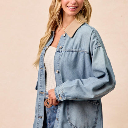 Woman wearing a light blue denim jacket on a beige background