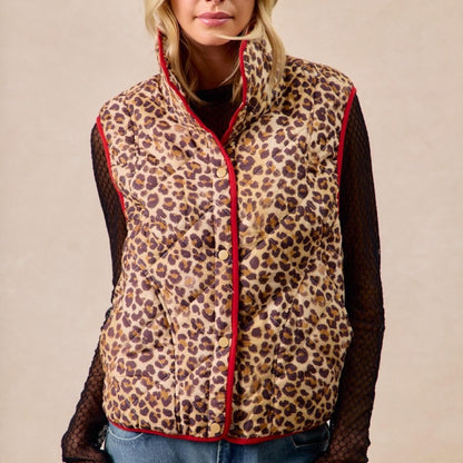 Person wearing a leopard print vest with red trim on a beige background