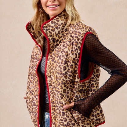 Woman wearing a leopard print vest with red trim on a beige background