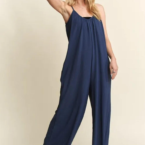 Navy blue jumpsuit worn by a person on a beige background