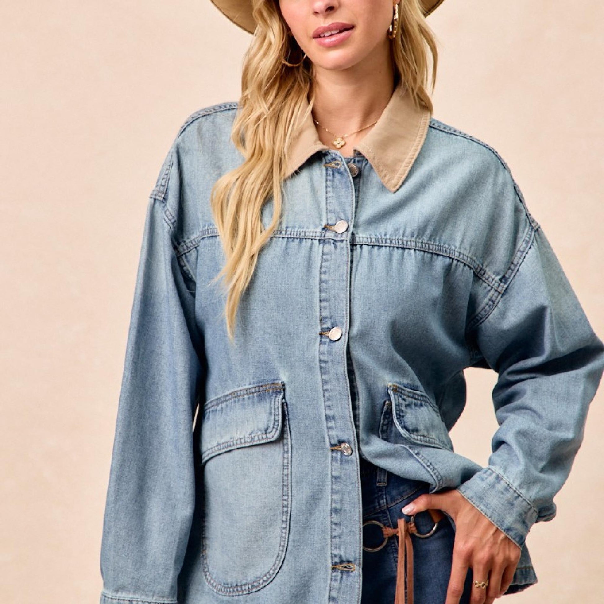 Woman wearing a denim jacket and hat against a beige background