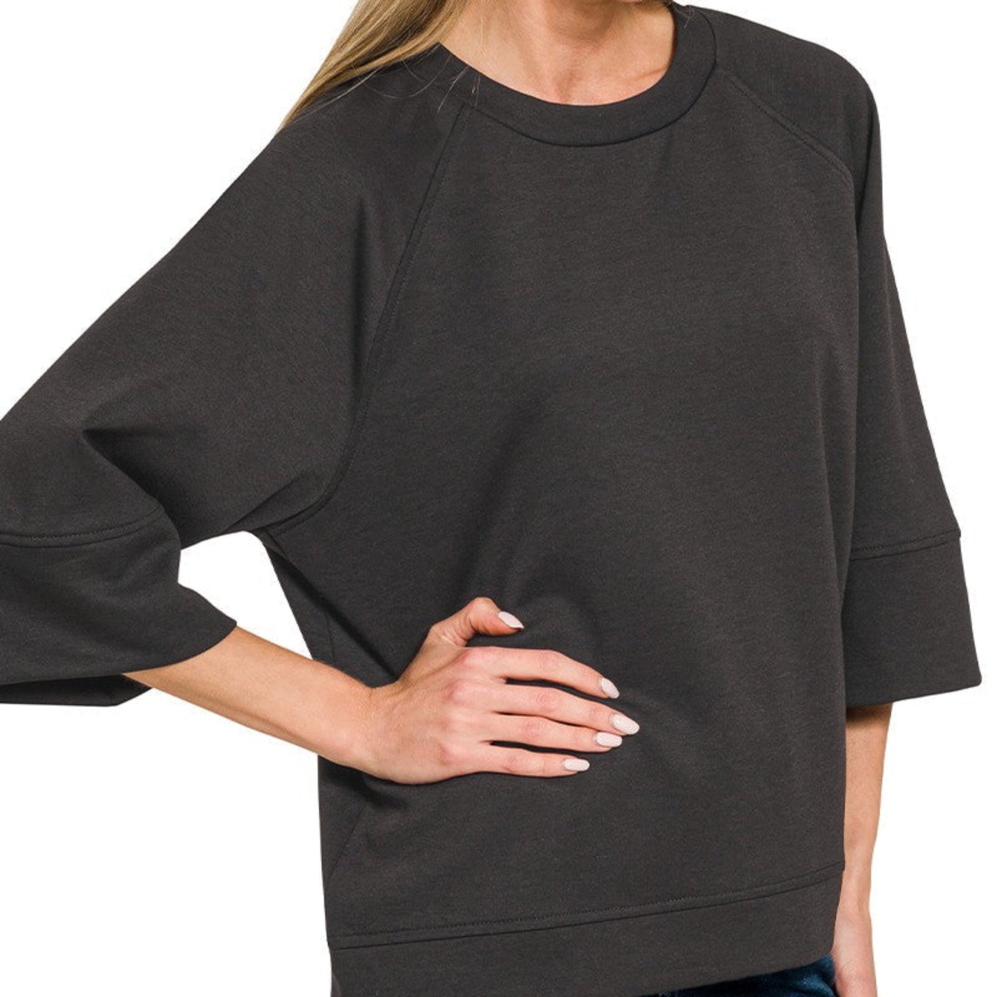 Woman wearing a dark gray oversized sweatshirt on a white background
