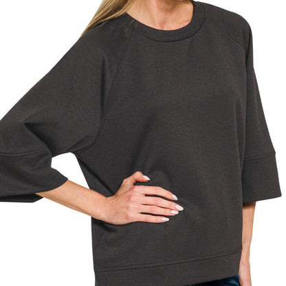 Woman wearing a dark gray oversized sweatshirt on a white background