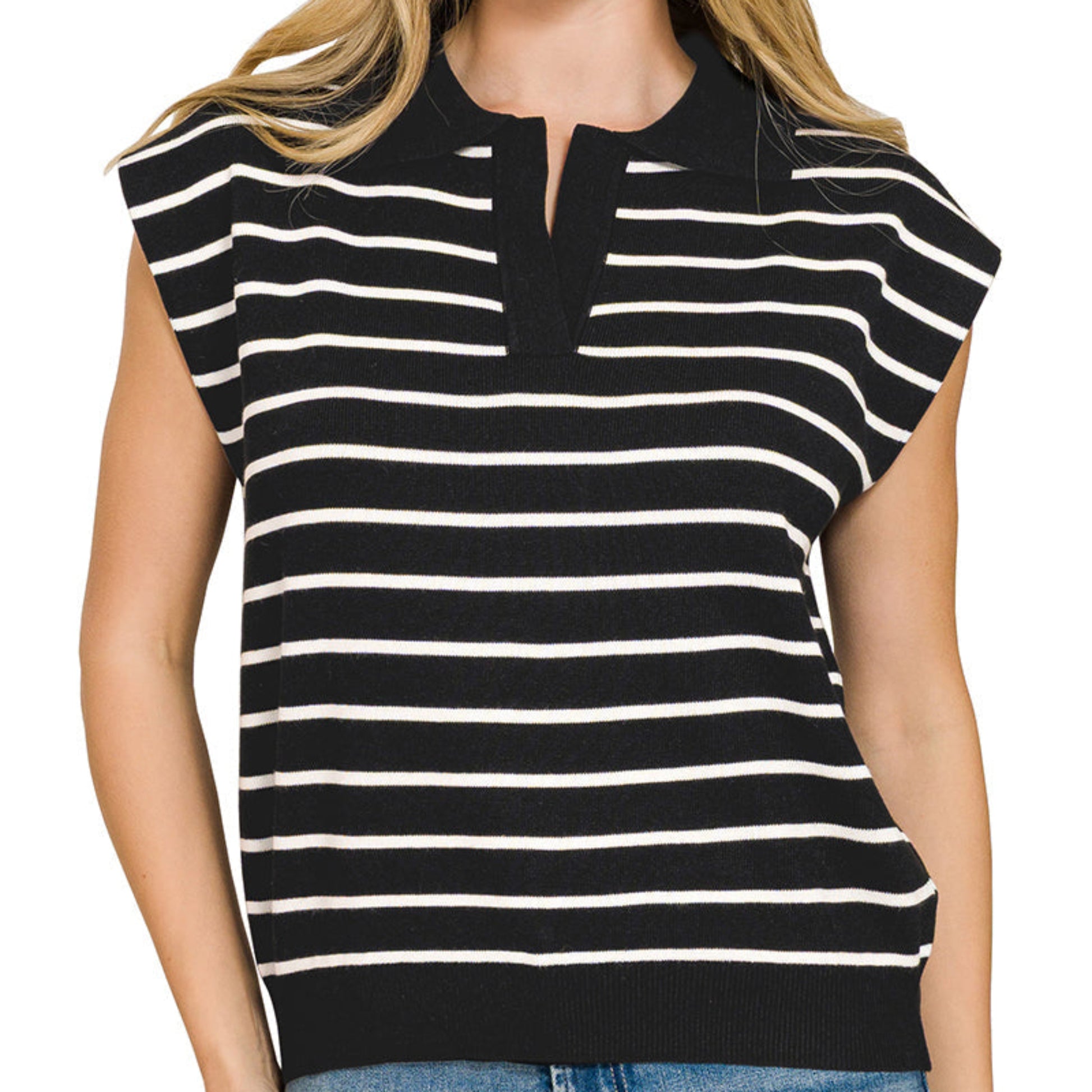 Woman wearing a black and white striped sleeveless top with blue jeans on a white background