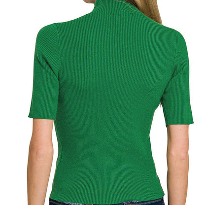 Green ribbed knit top worn by a person on a white background