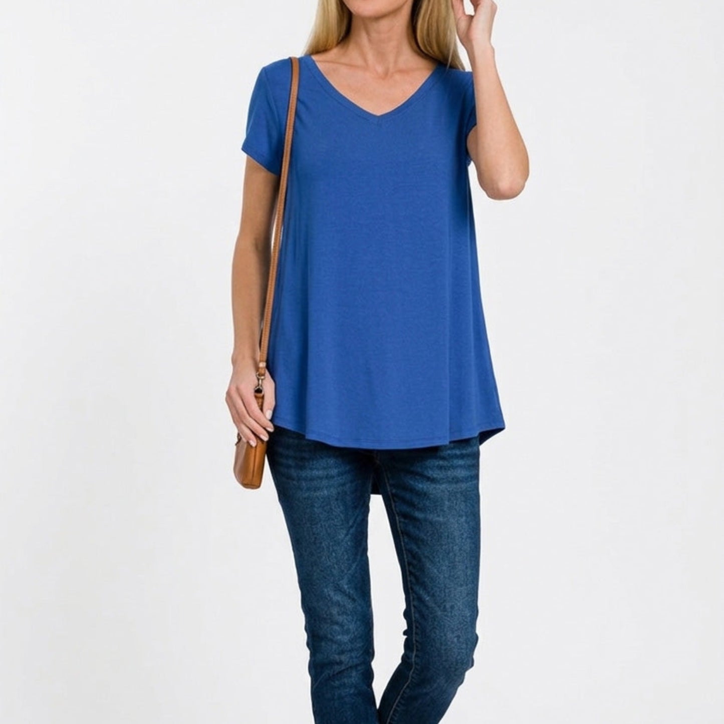 Woman wearing a blue t-shirt and jeans on a white background