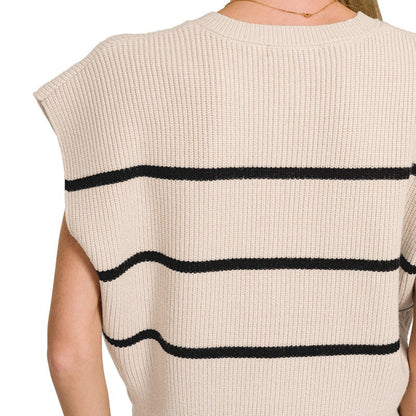 Beige sleeveless top with black stripes worn by a person on a white background