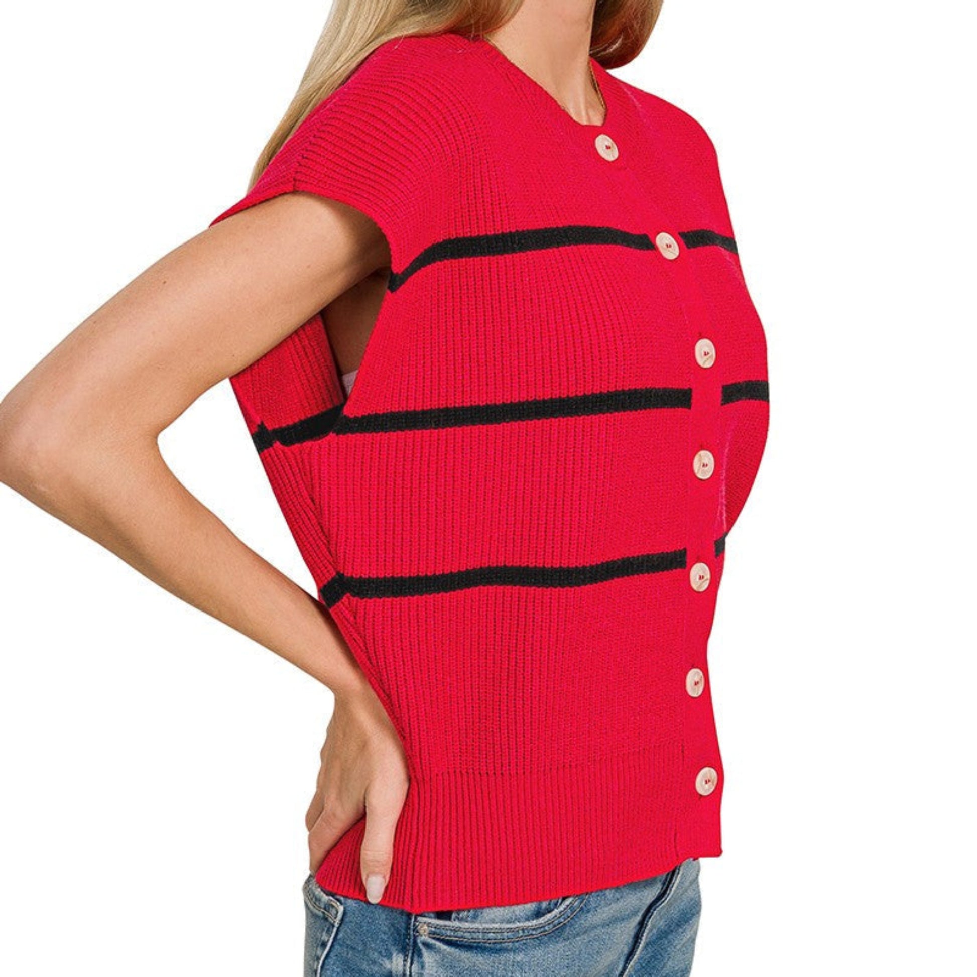 Woman wearing a red sleeveless sweater with black stripes and buttons on a white background