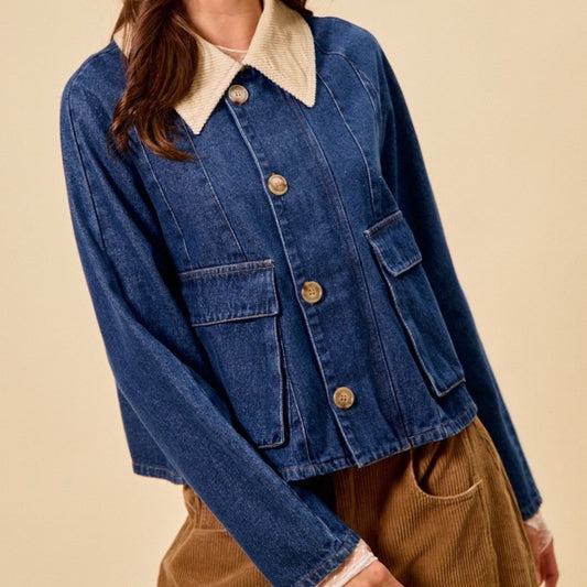 Woman wearing a blue denim jacket with a cream collar and beige pants against a beige background