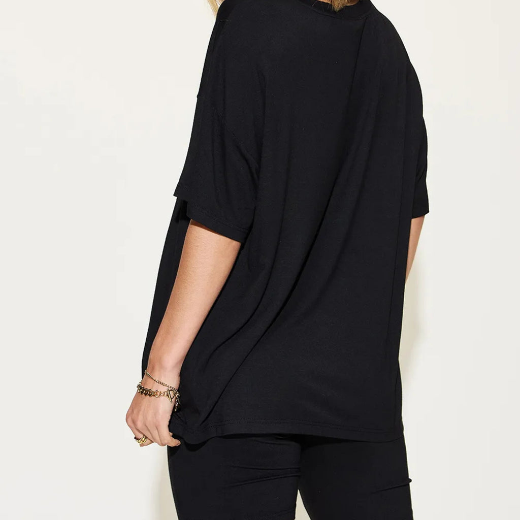 Person wearing a black outfit on a plain background