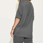 Person wearing a gray oversized t-shirt on a white background