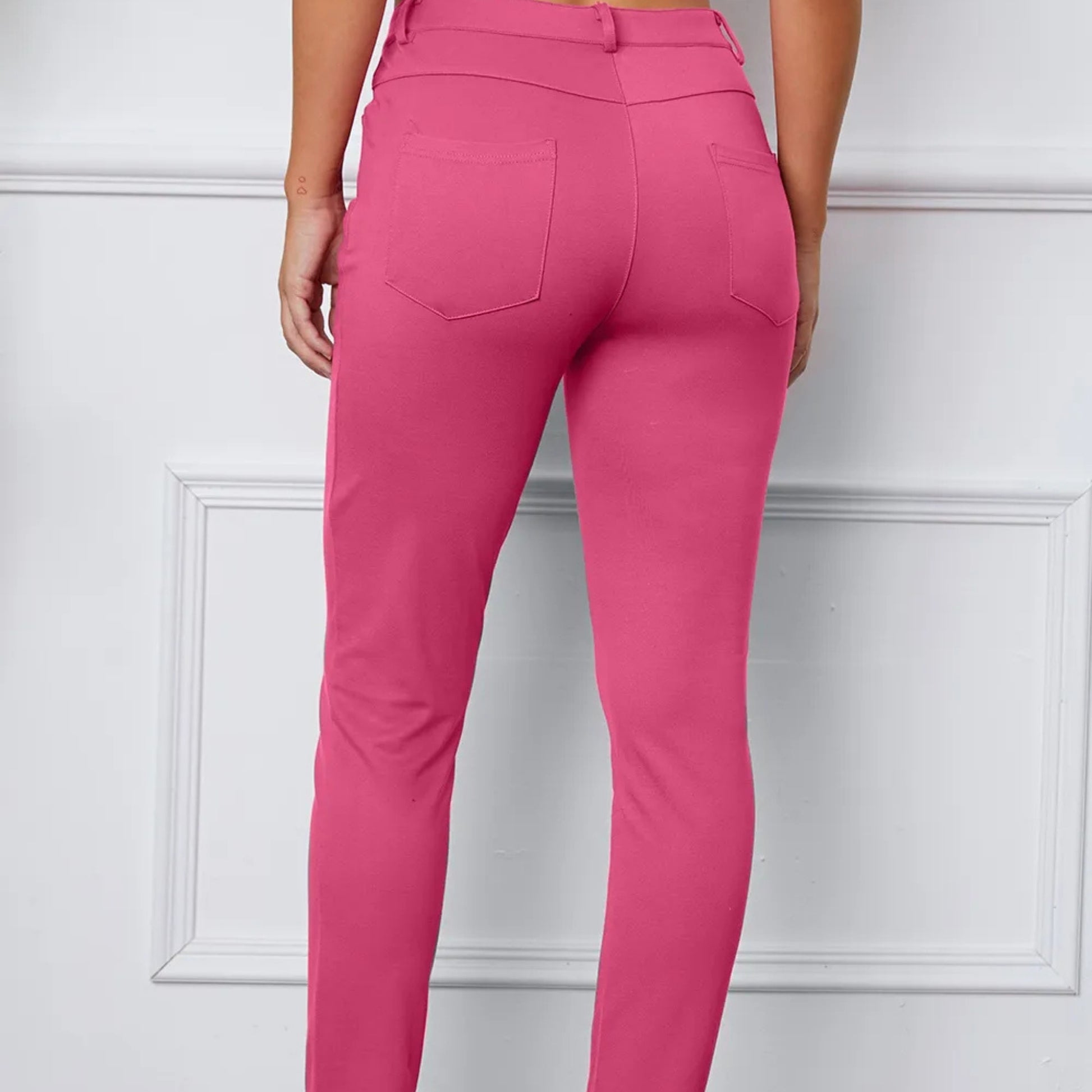 Pink pants worn by a person on a white background