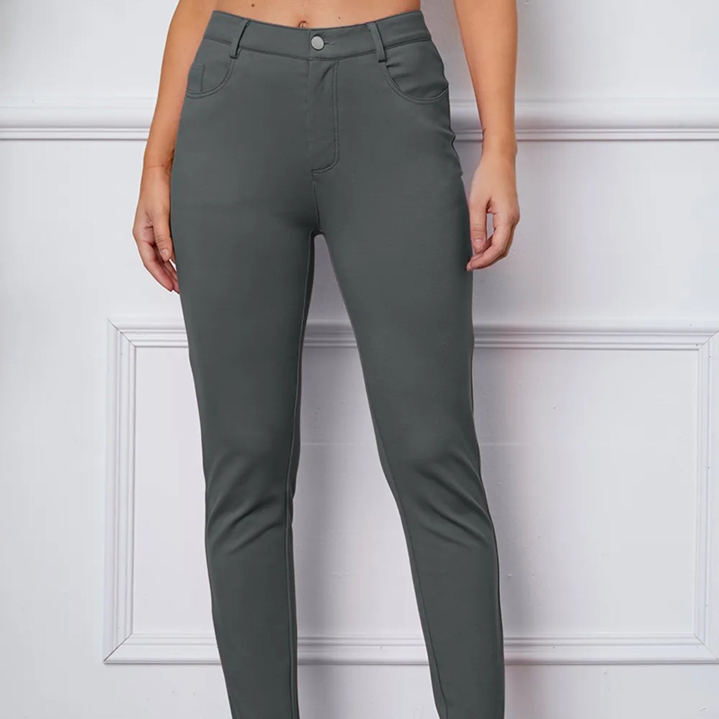 Gray pants worn by a person on a white background