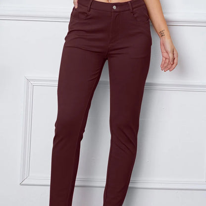 Maroon pants worn by a person against a white wall