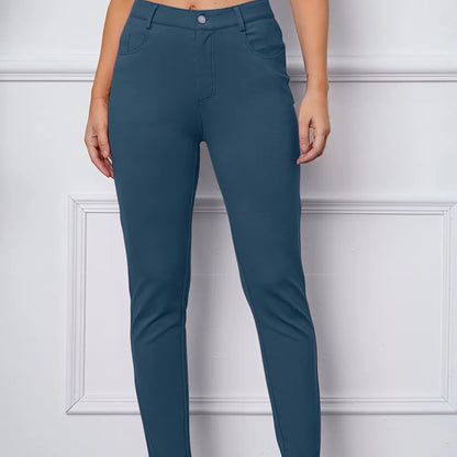 Teal pants worn by a person against a white paneled wall