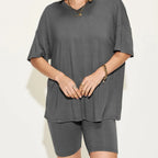 Person wearing a gray oversized t-shirt and shorts set on a white background