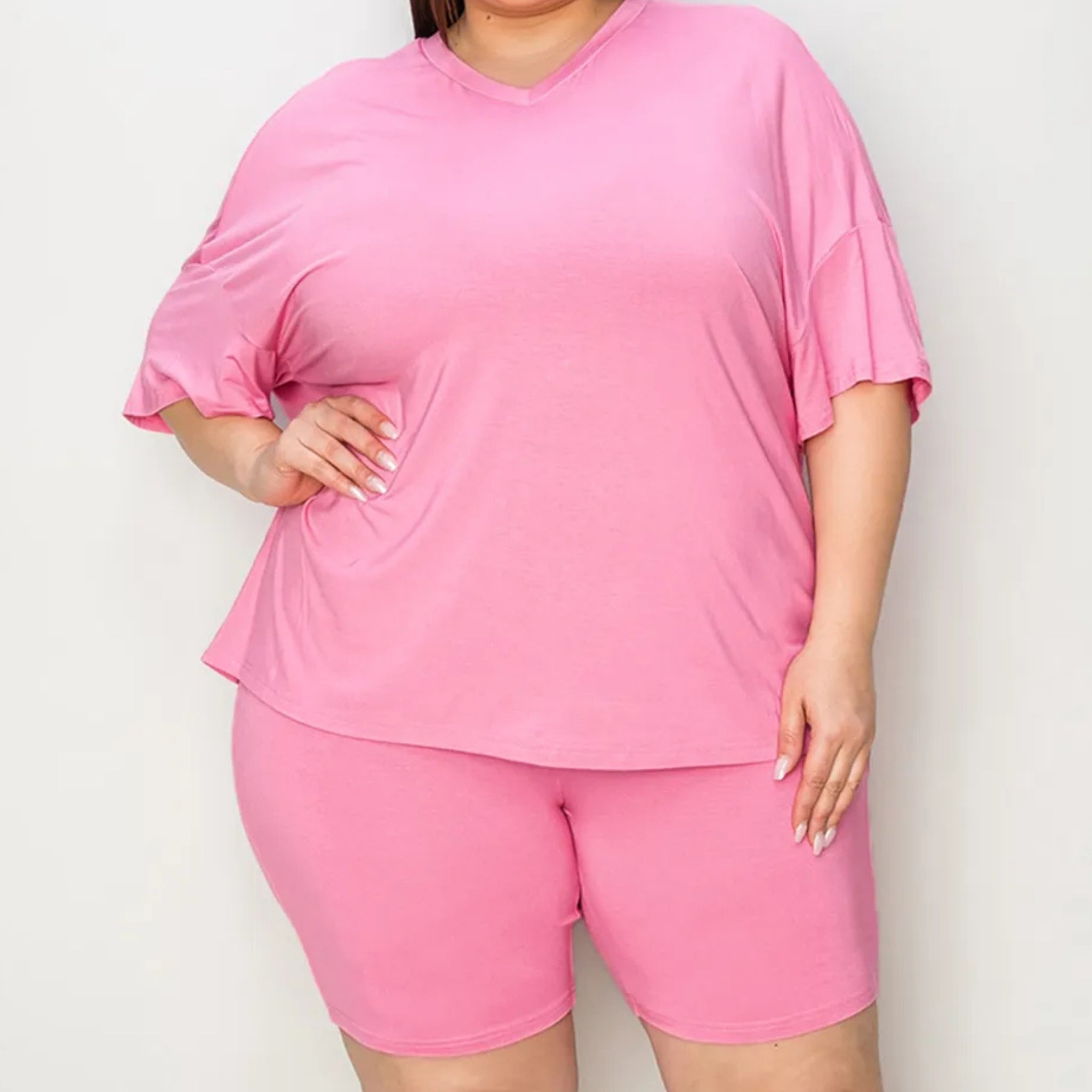 Oversized Person wearing a pink outfit with a top and shorts on a plain background