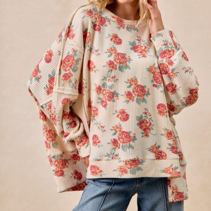Floral patterned sweater worn by a person on a beige background
