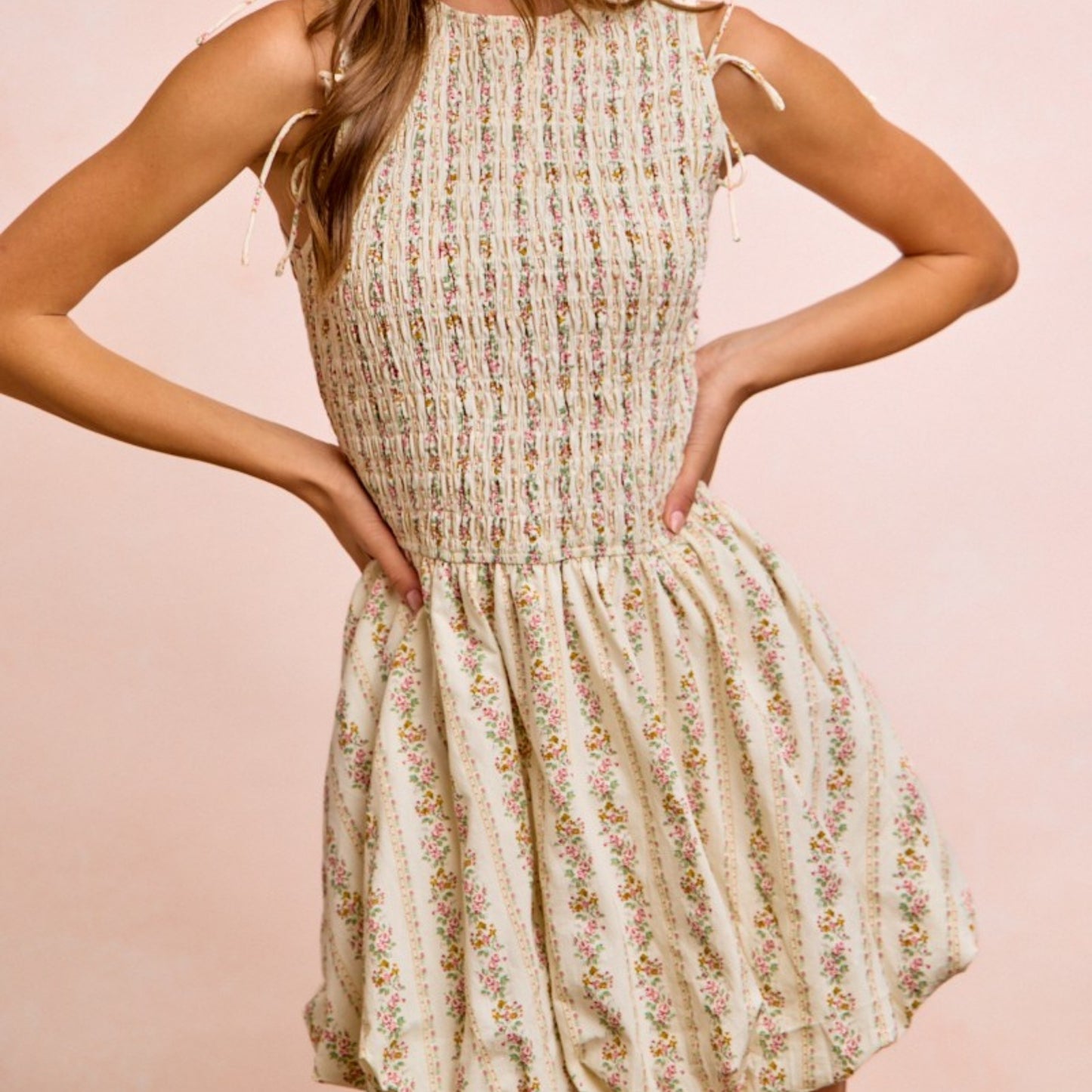 Woman wearing a floral dress against a pink background