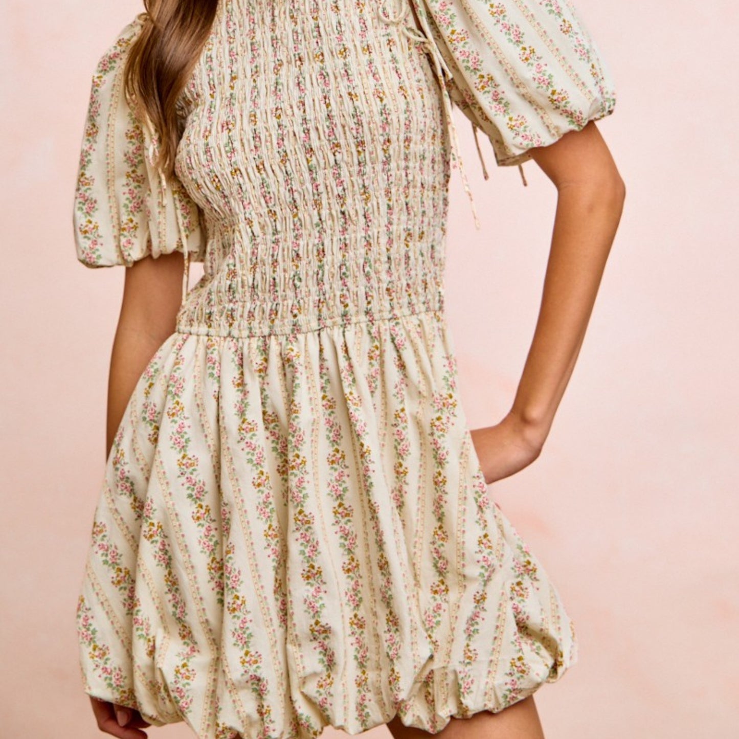 Floral dress worn by a person on a pink background