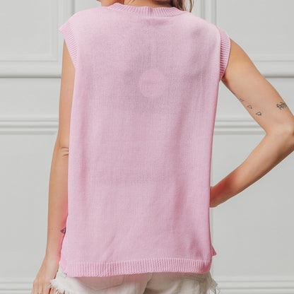 Person wearing a pink sleeveless sweater against a white background