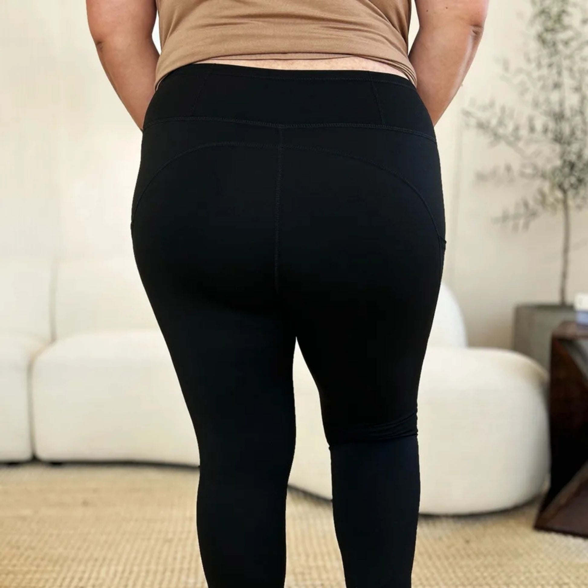 Person wearing black leggings in a living room setting