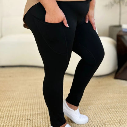 Person wearing black leggings and white sneakers on a beige carpet.