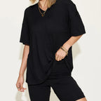 Person wearing a black outfit with gold jewelry against a white background