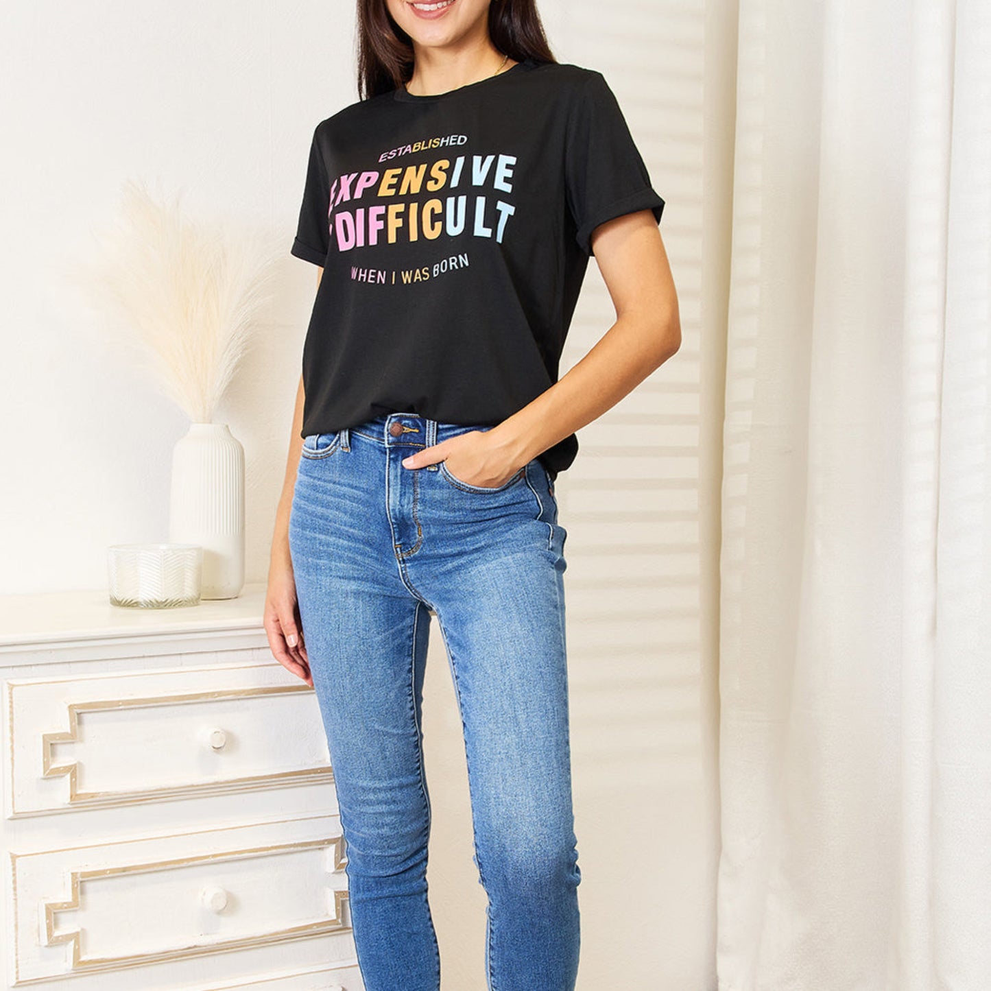 Folded black graphic t-shirt highlighting the cuffed sleeves and neck.
