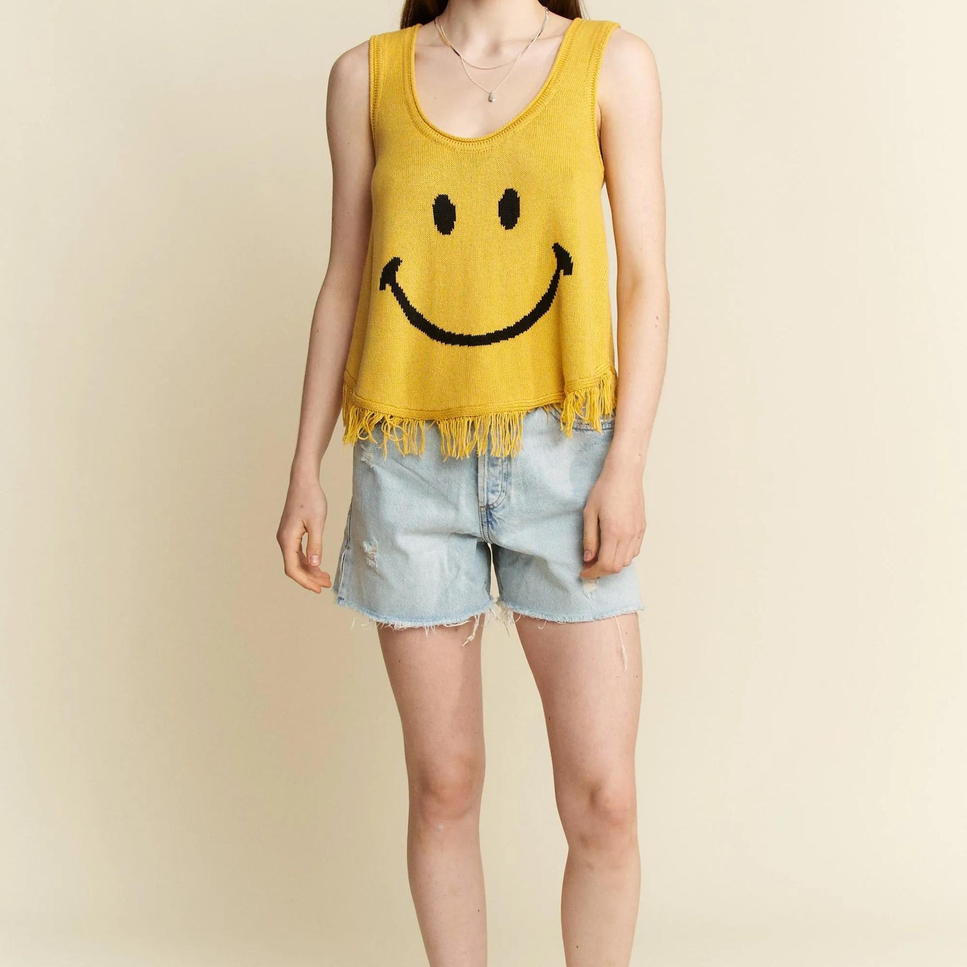 Detailed view of the knit texture and fringe hem on the yellow bohemian tank.
