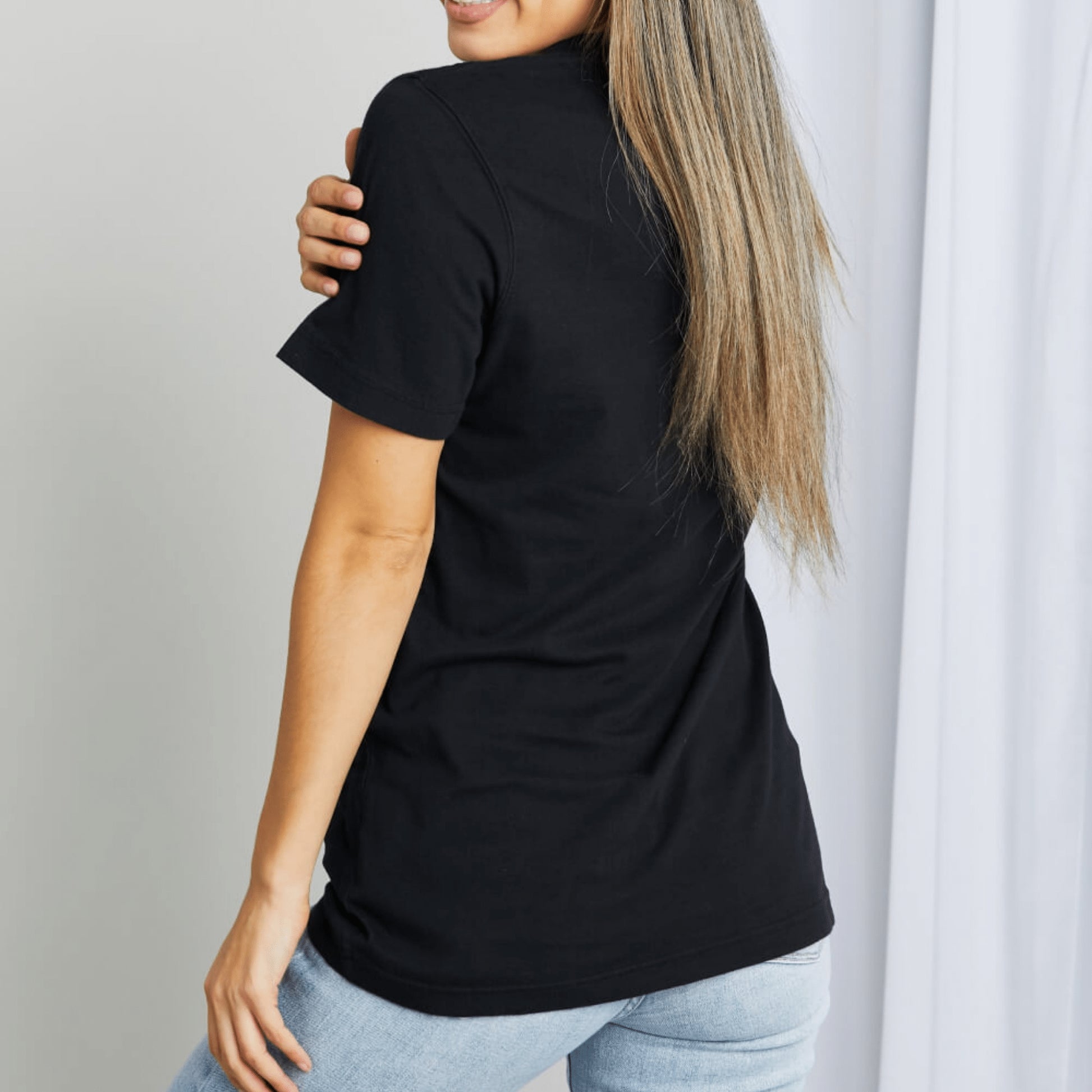 Alternative angle of the cotton graphic tee styled with sunglasses and casual denim.