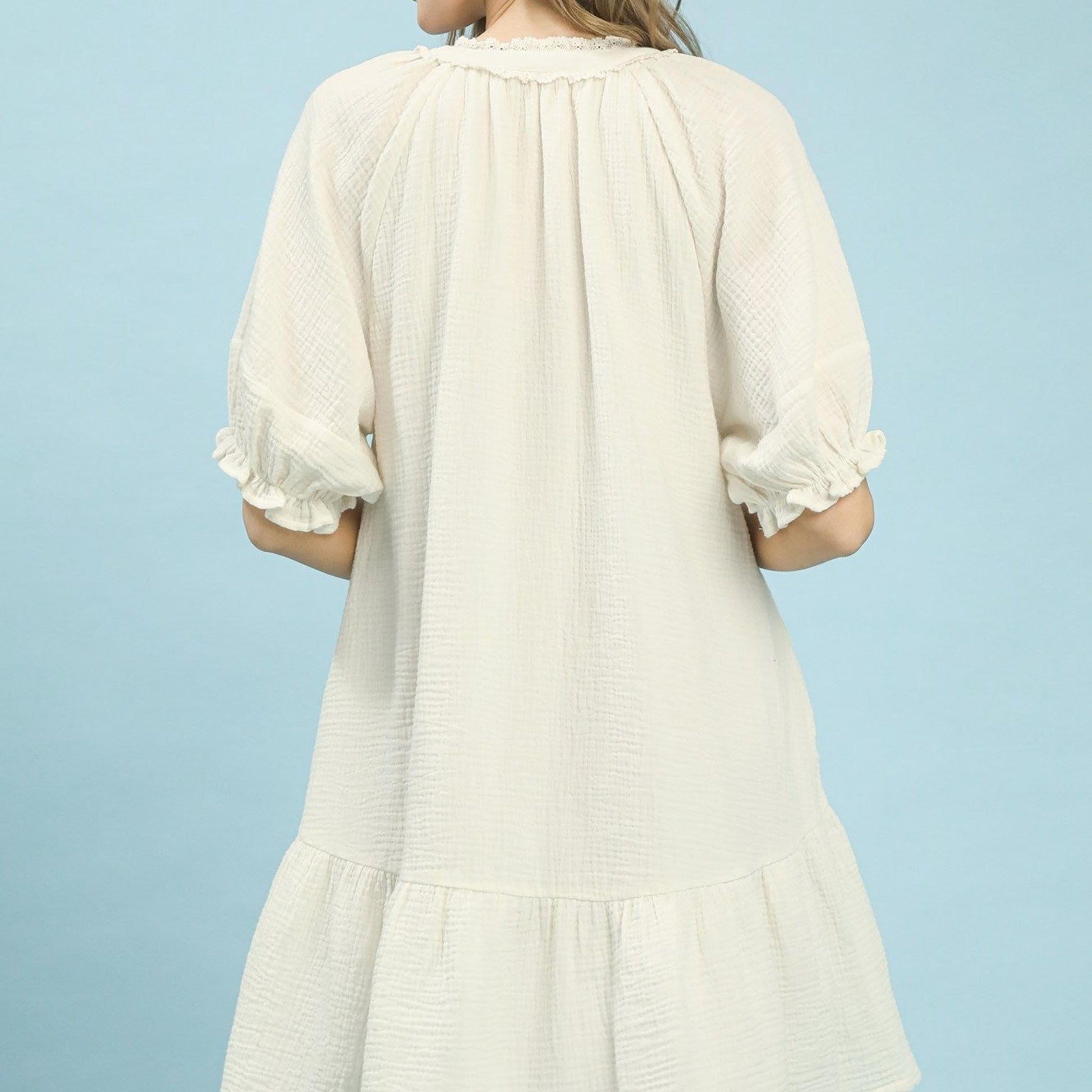 White dress with ruffled sleeves on a light blue background