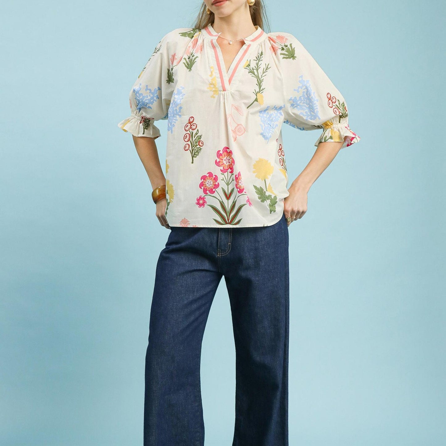 Lifestyle view of the Umgee floral puff sleeve top paired with denim for a bohemian-inspired look.