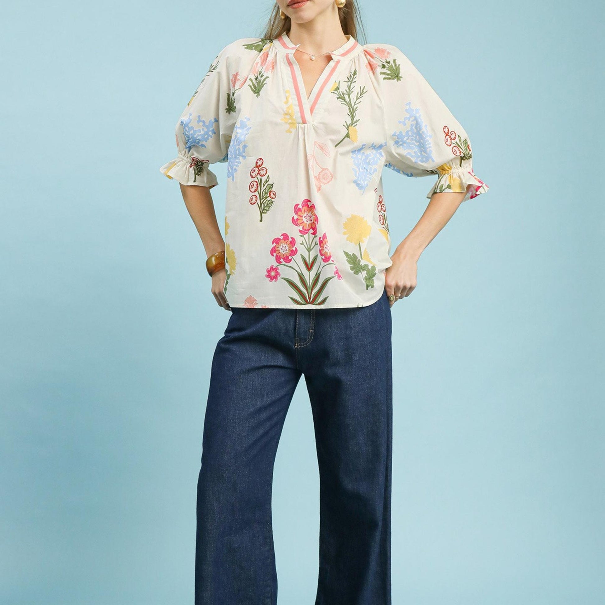 Lifestyle view of the Umgee floral puff sleeve top paired with denim for a bohemian-inspired look.