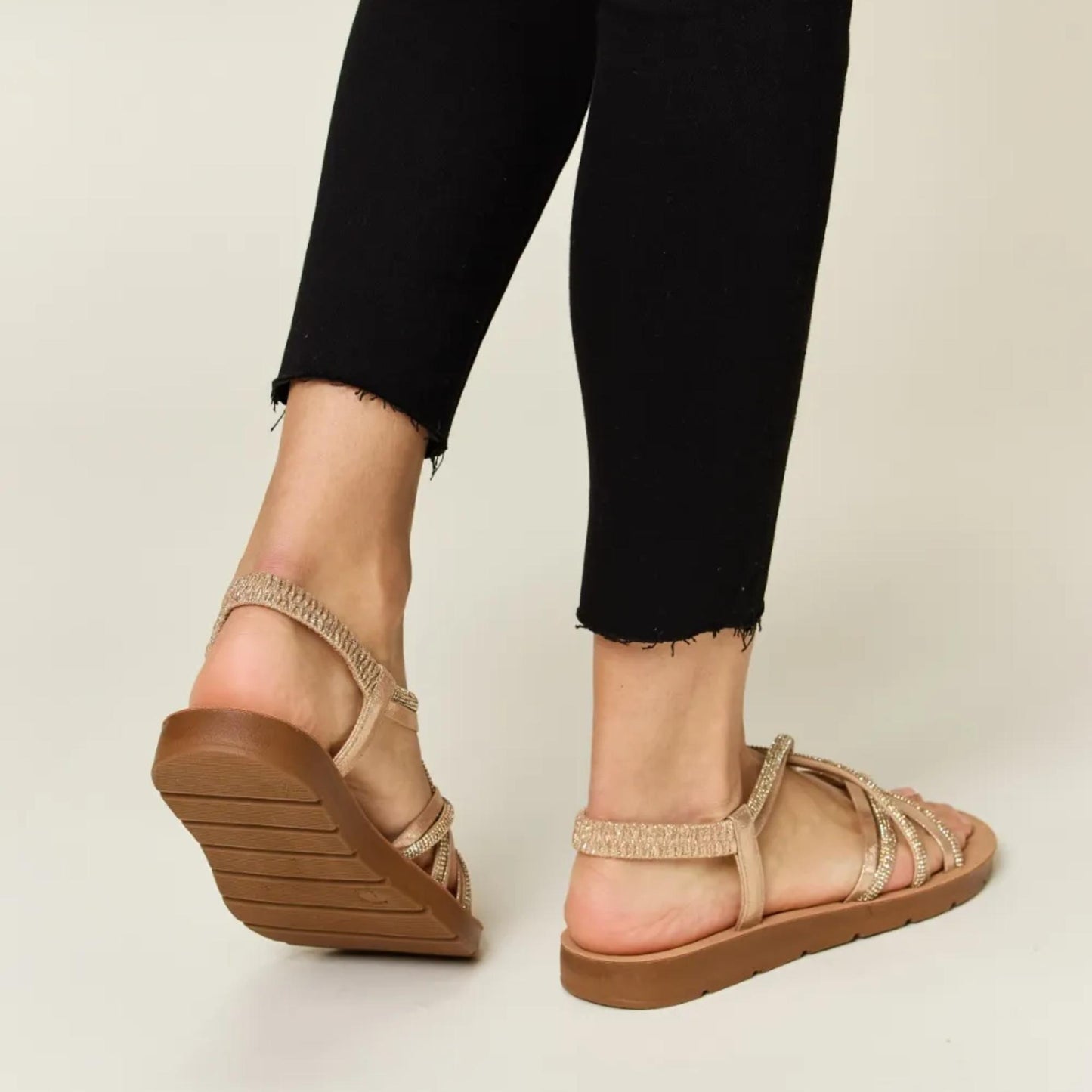 Back view of the gold rhinestone crisscross flat sandals highlighting the secure heel design.