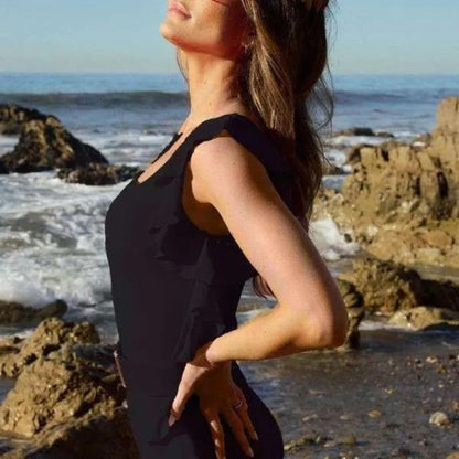 Side profile of the Davi & Dani black ruffle swimsuit highlighting the flattering asymmetric silhouette.