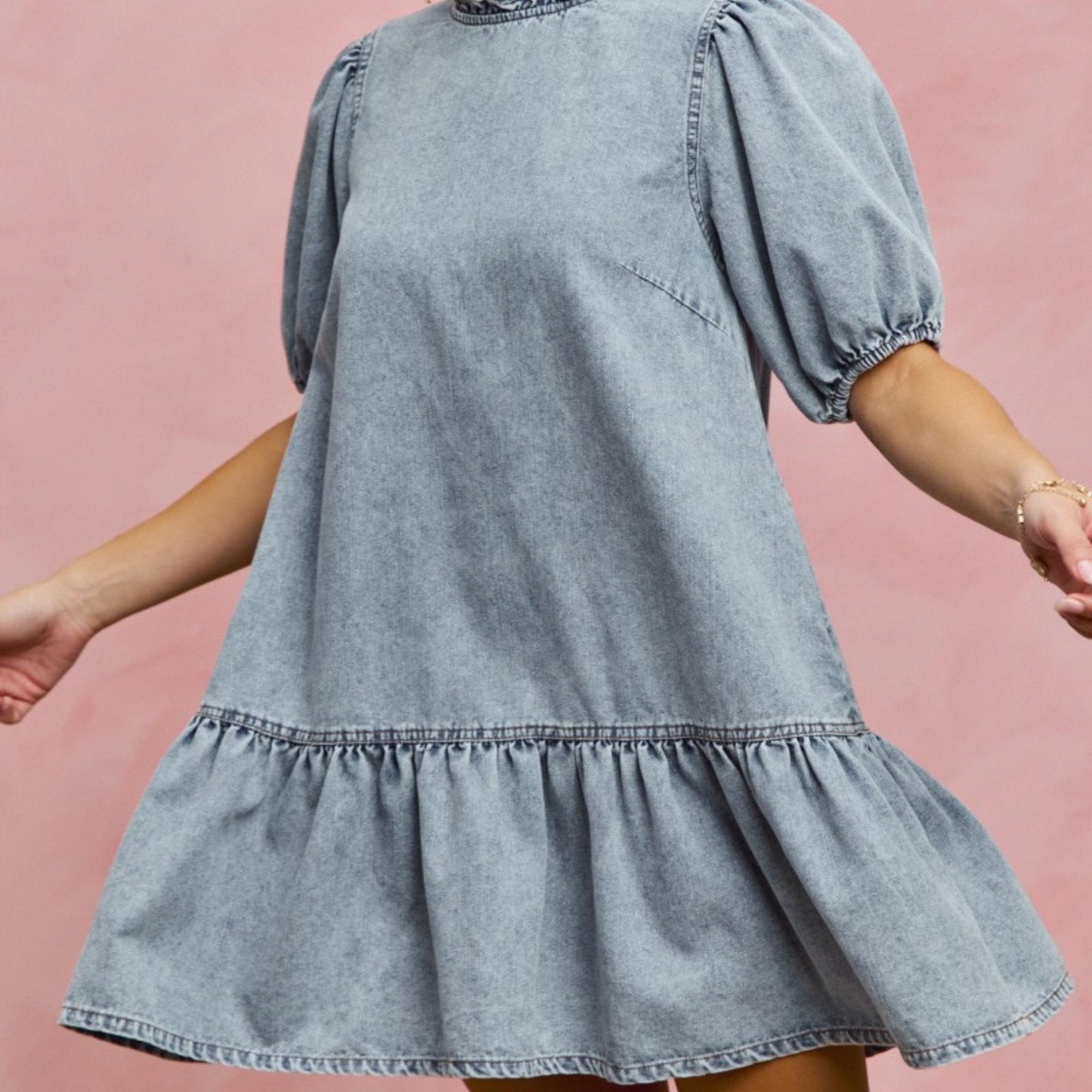 Side profile of the SO ME tiered denim mini dress with ruffle hem detail.