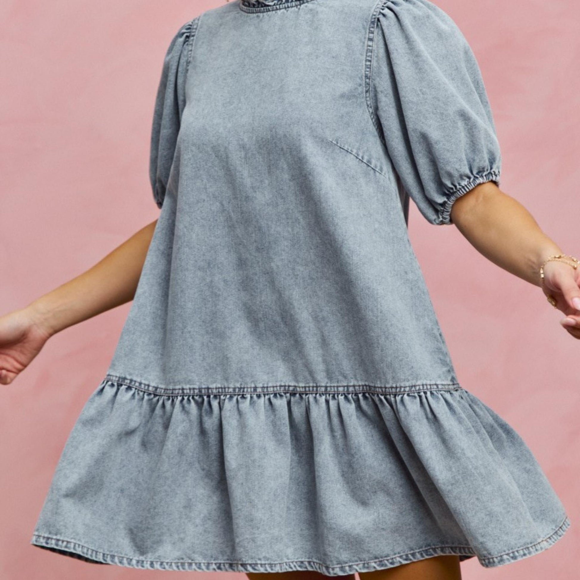 Side profile of the SO ME tiered denim mini dress with ruffle hem detail.