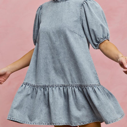 Side profile of the SO ME tiered denim mini dress with ruffle hem detail.